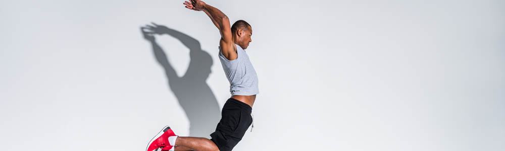 Man jumping in the air, with shadow behind him Man jumping in the air, with shadow behind him
